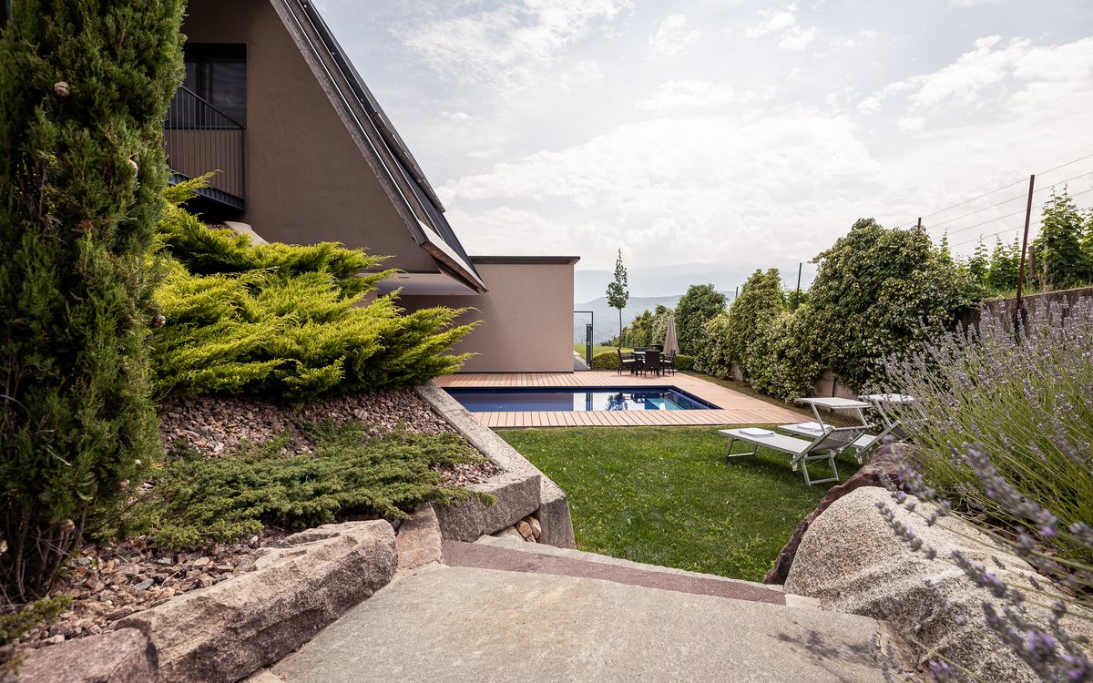 Giardino con piscina d'acqua salata e prato per prendere il sole a Caldaro, Alto Adige